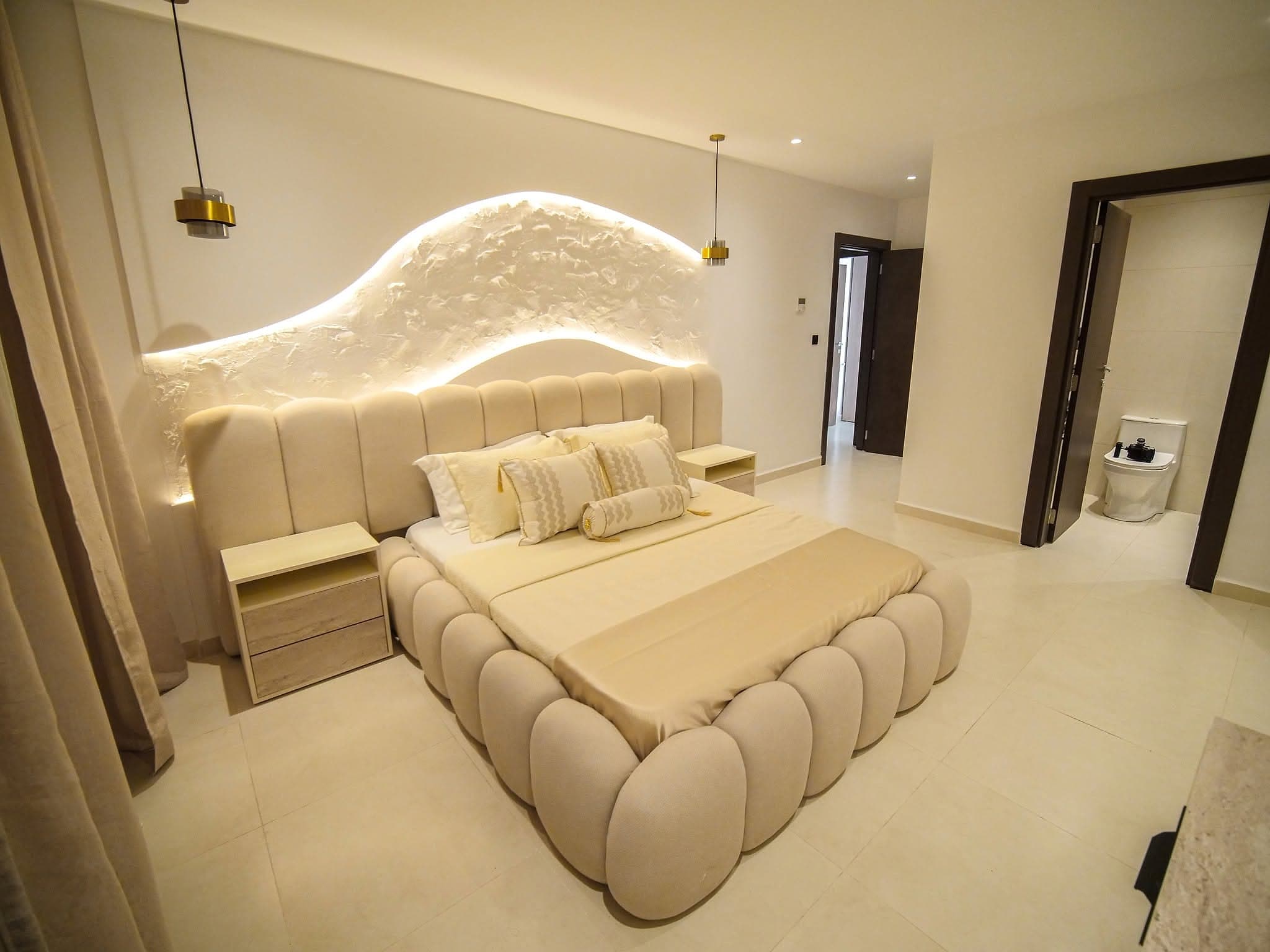 Chambre parentale avec tête de lit capitonnée et éclairage d'ambiance