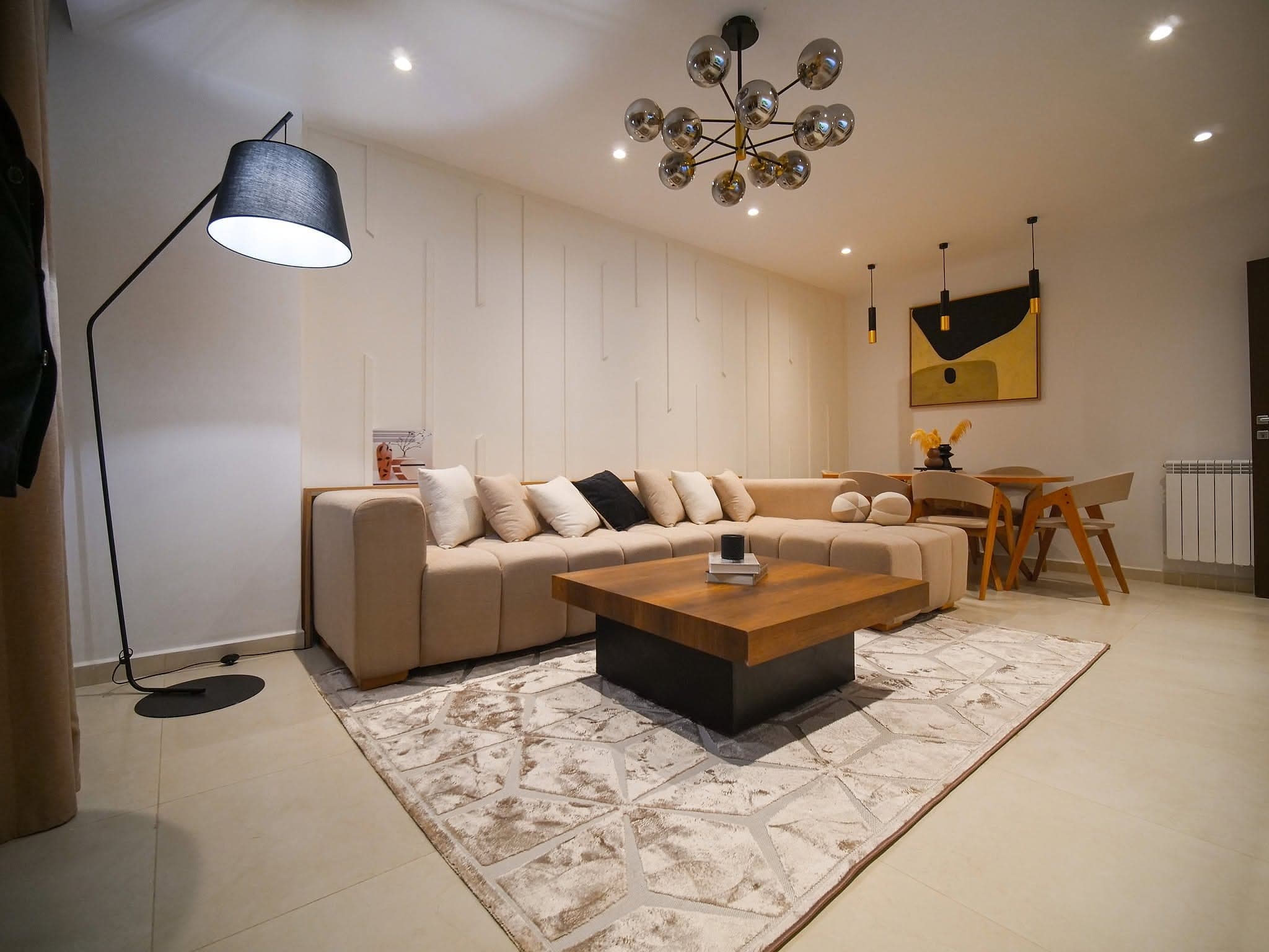 Salon d'un appartement témoin de la résidence Les Platanes, canapé d'angle et éclairage design